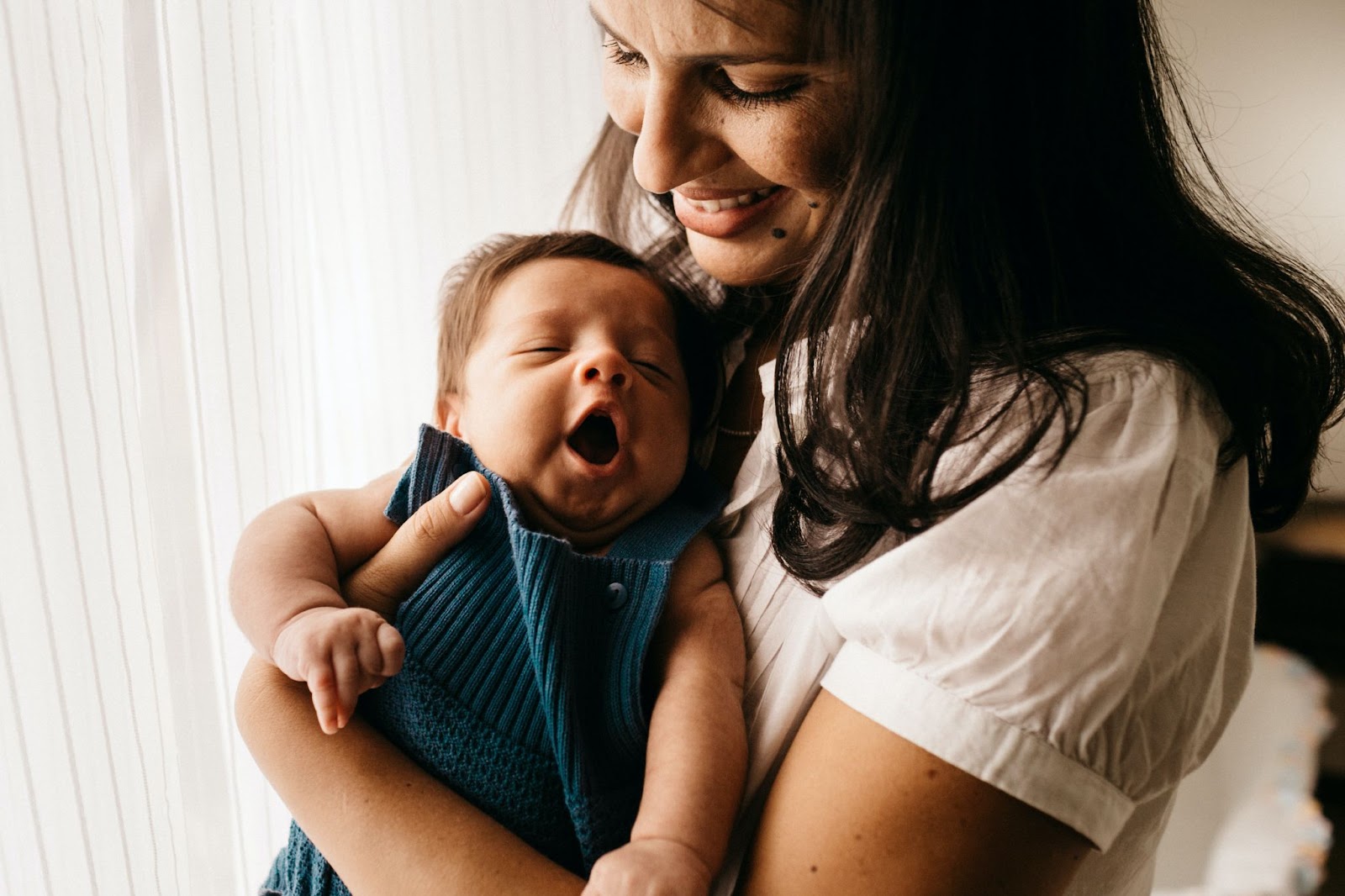 Woman smiles holding new baby