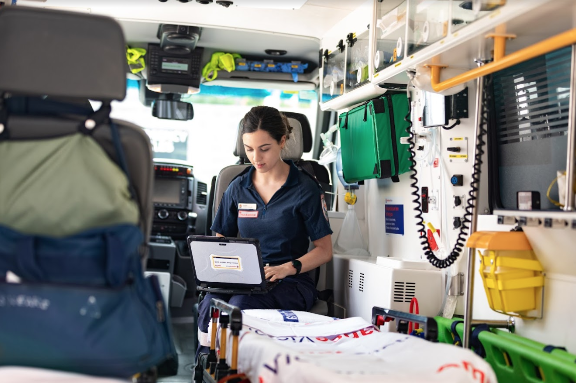Photo of Eastern Health emergency worker on a device in an ambulance