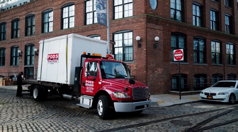 PODS truck with a moving container in a city