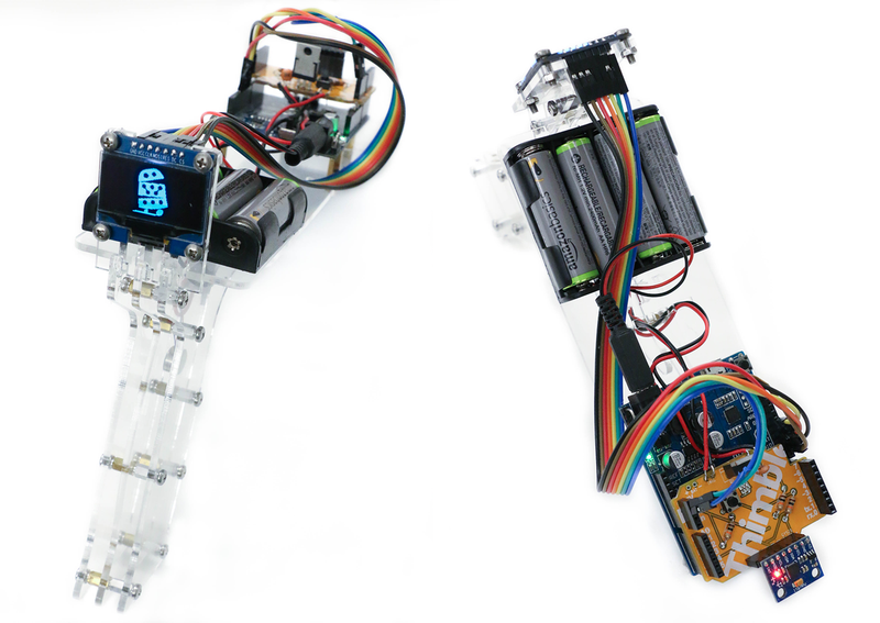 This is an image of Thimble's AI Kit completed. It appears like a clear plastic video game gun with a small screen, battery pack, and multi-colored wiring.