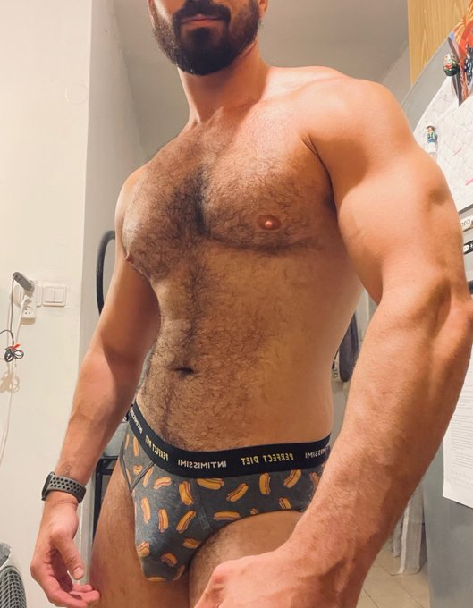 Thick Macho posing in underwear covered in hot dog pattern shirtless in the kitchen