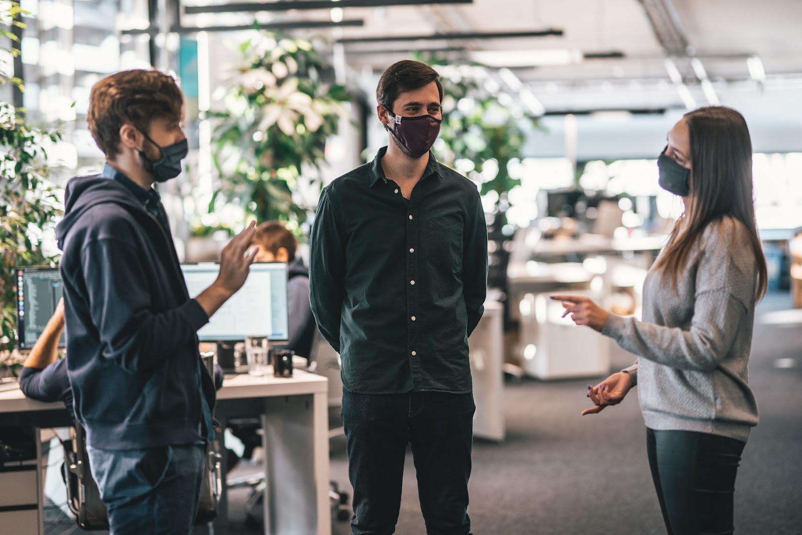 People chatting at work with masks on, potential boomerang employees hire