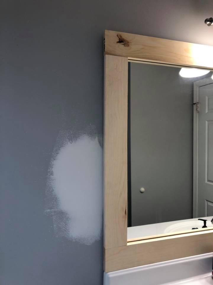 Adding pine boards to a bathroom mirror to create a frame.