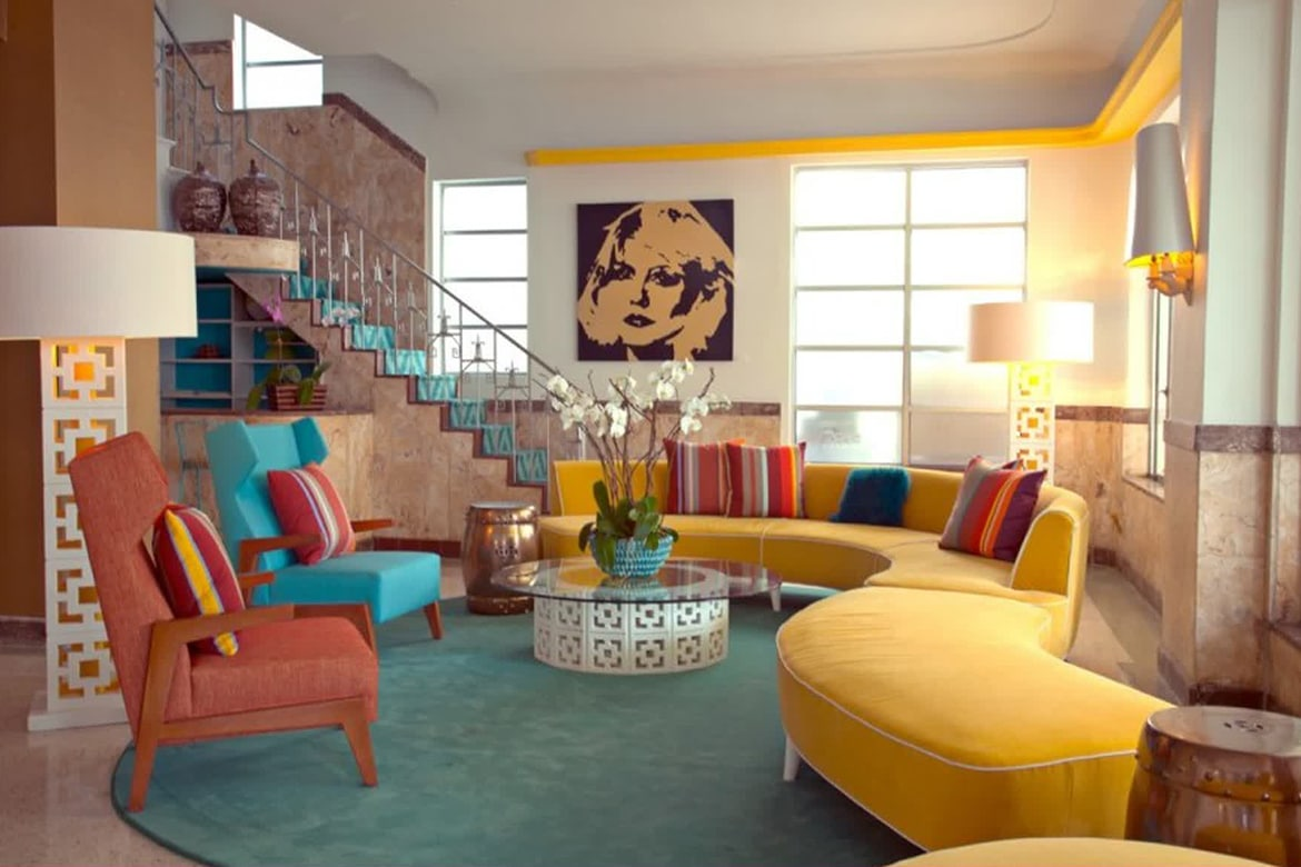 Retro-inspired living room with bright couches and a mix of patterns with a painting as a centerpiece