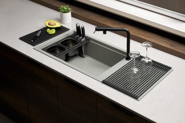 A kitchen sink with a faucet and wine glasses

Description automatically generated