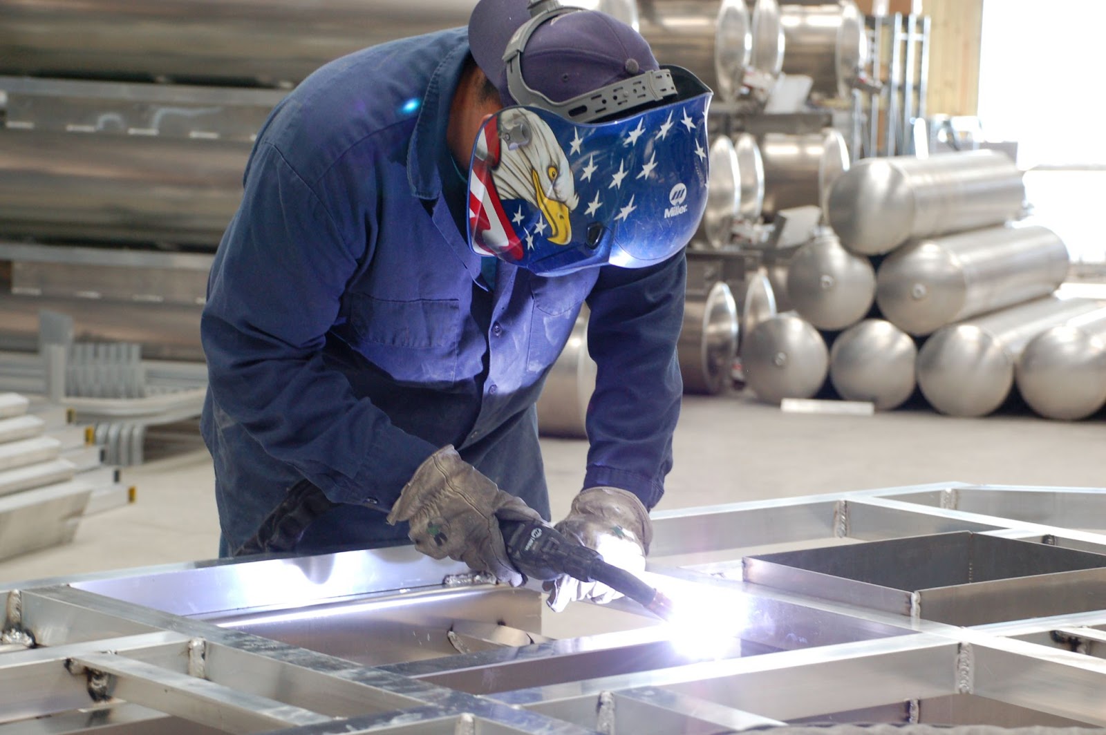 man welding aluminum pontoon boat