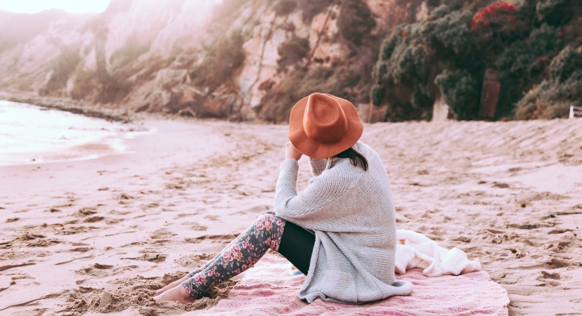 Woman sitting on the beach at Point Dume in Malibu, CA