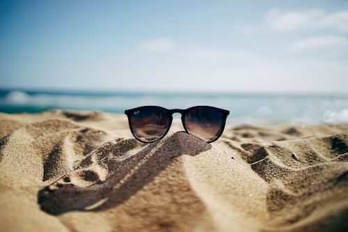 A pair of sunglasses on a beach