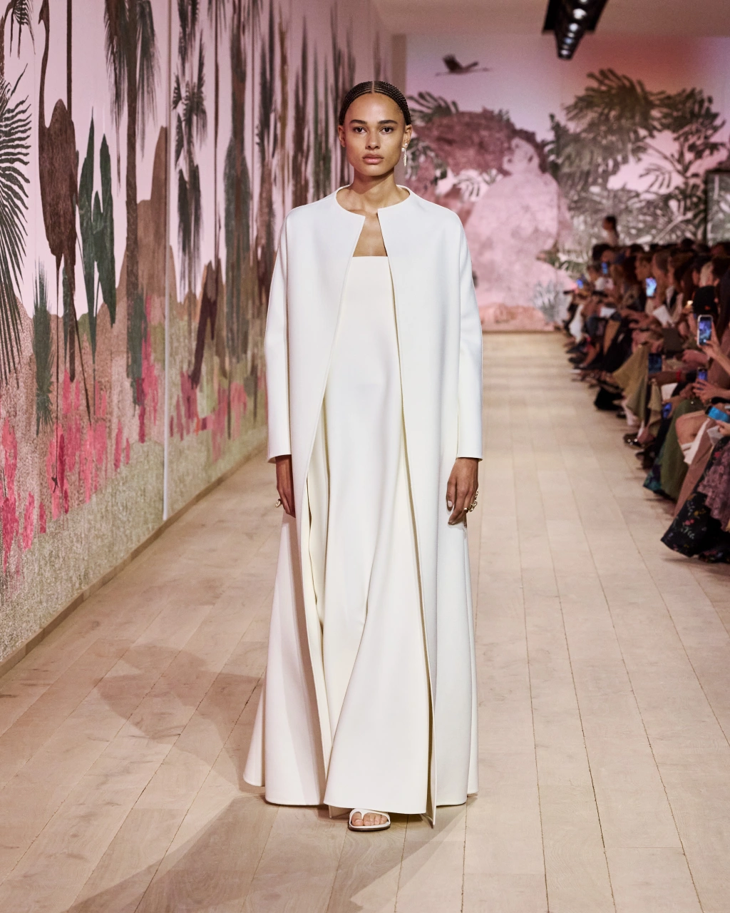 Model draped in a long white dress and coat for Christian Dior at the Paris Fashion Week Haute Couture 