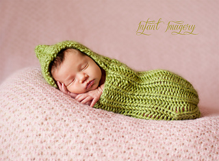 newborn baby in green cocoon