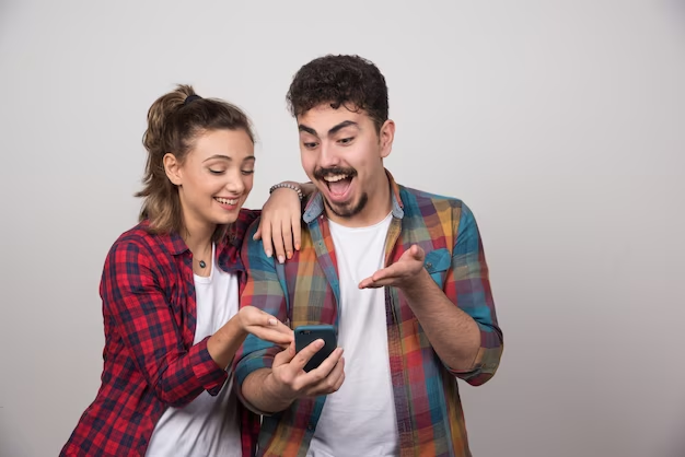 A couple surprised to find amusing Facebook quotes on their phone.