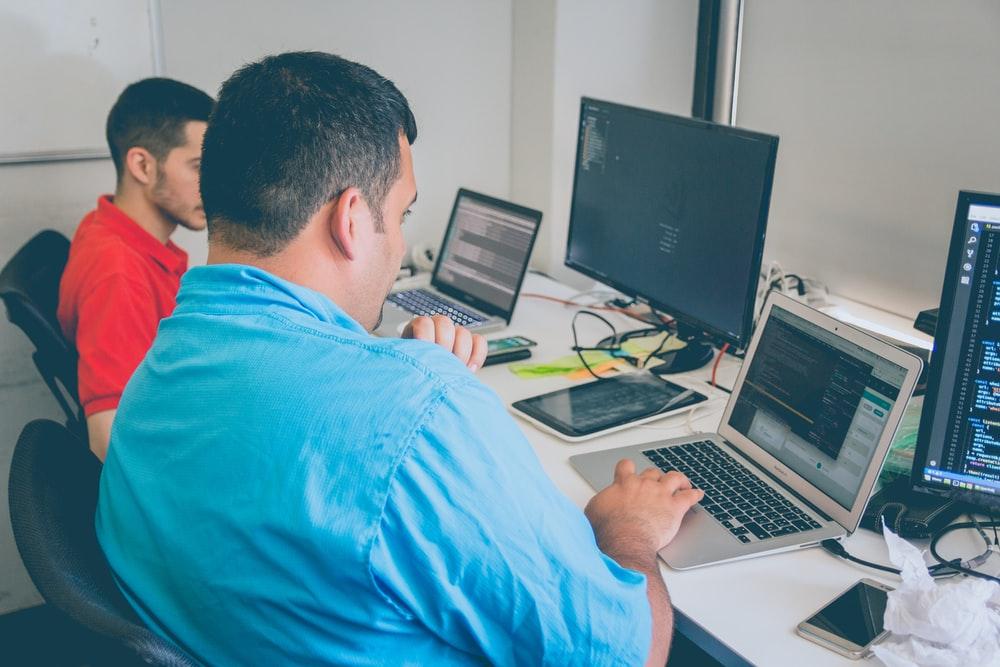 two men using laptop