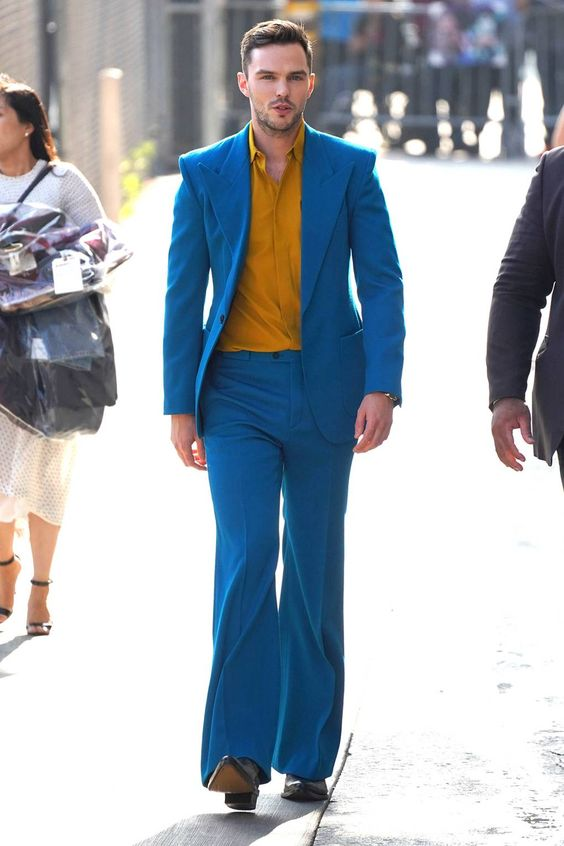 a man wearing a blue suit with a dark yellow shirt