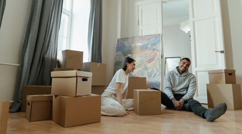 A couple packing boxes for their move