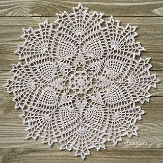 crochet thread doily on wooden background