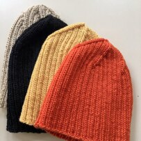 four different color of knit hats lying flat