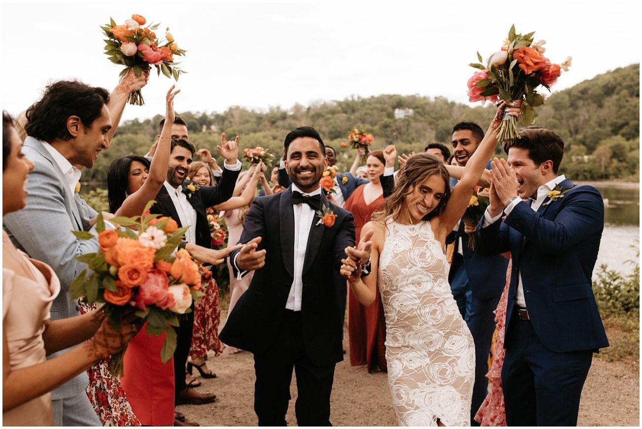 Couple smiling and celebrating with friends at their wedding reception