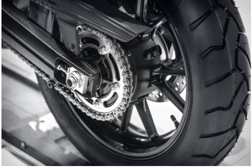 A motorcycle chain and tire shown getting a tune-up. 