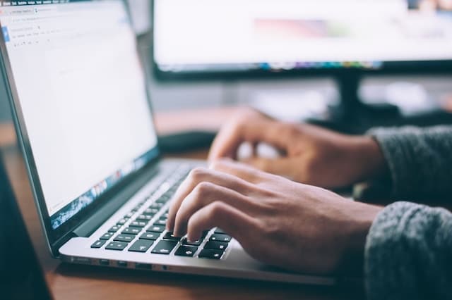 person writing on a laptop