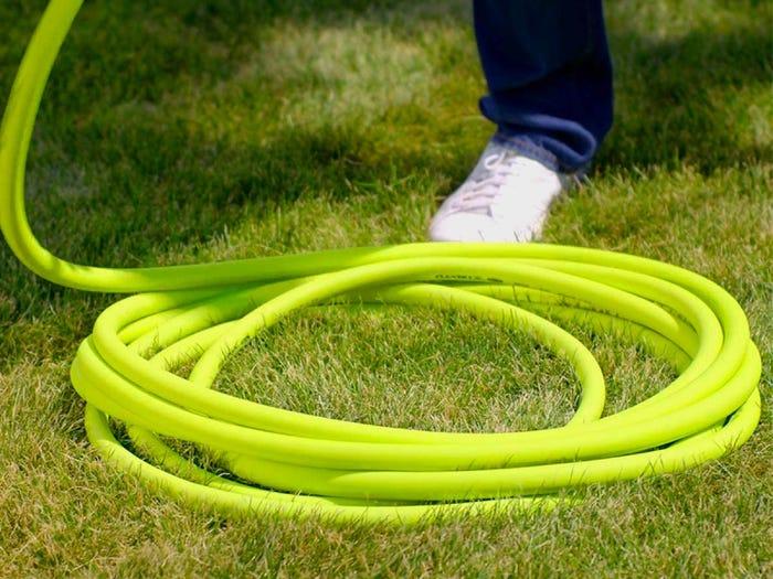 neon yellow flexzilla garden hose coiled on the grass which we're testing next for the best garden hose 2021