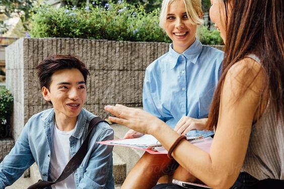 Three College Students Talking On Campus by Jayme Burrows