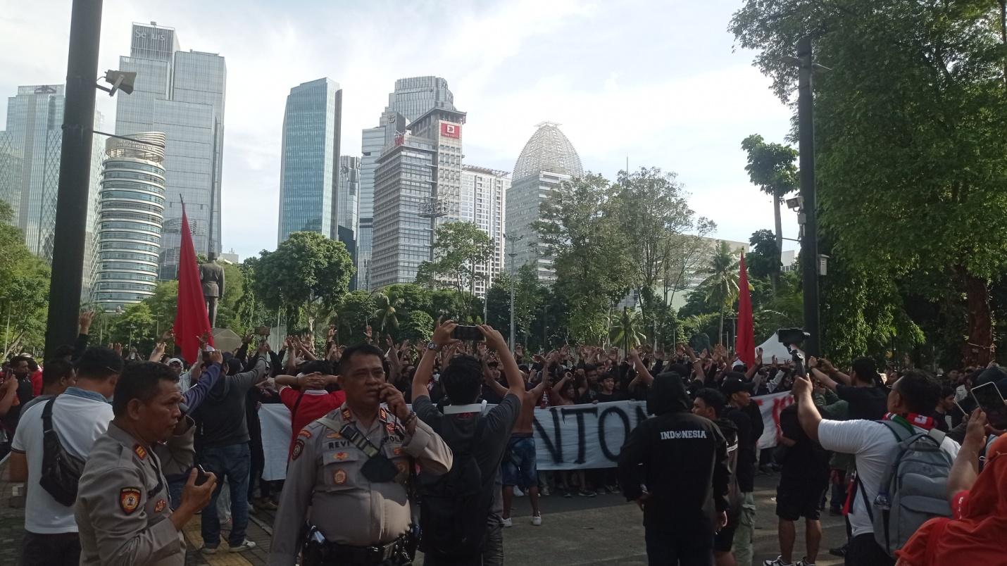 Pawai Ultras Garuda Indonesia sambil membentangkan spanduk protes.