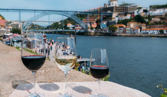 three glasses of wine next to douro river