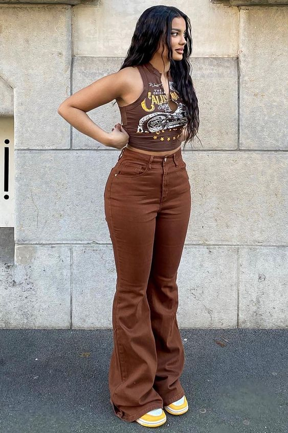 a lady wearing brown high-rise flared jeans with a tank top and sneakers