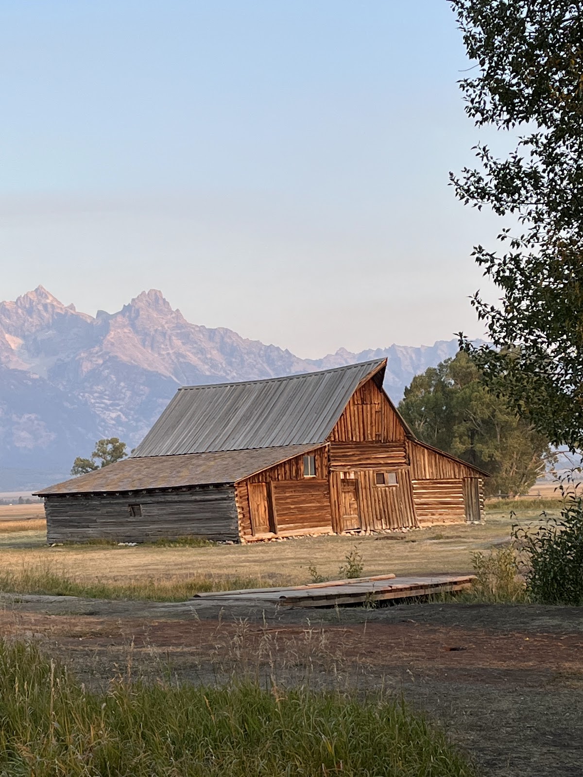 old wood barn in a grassland with mountain at the back