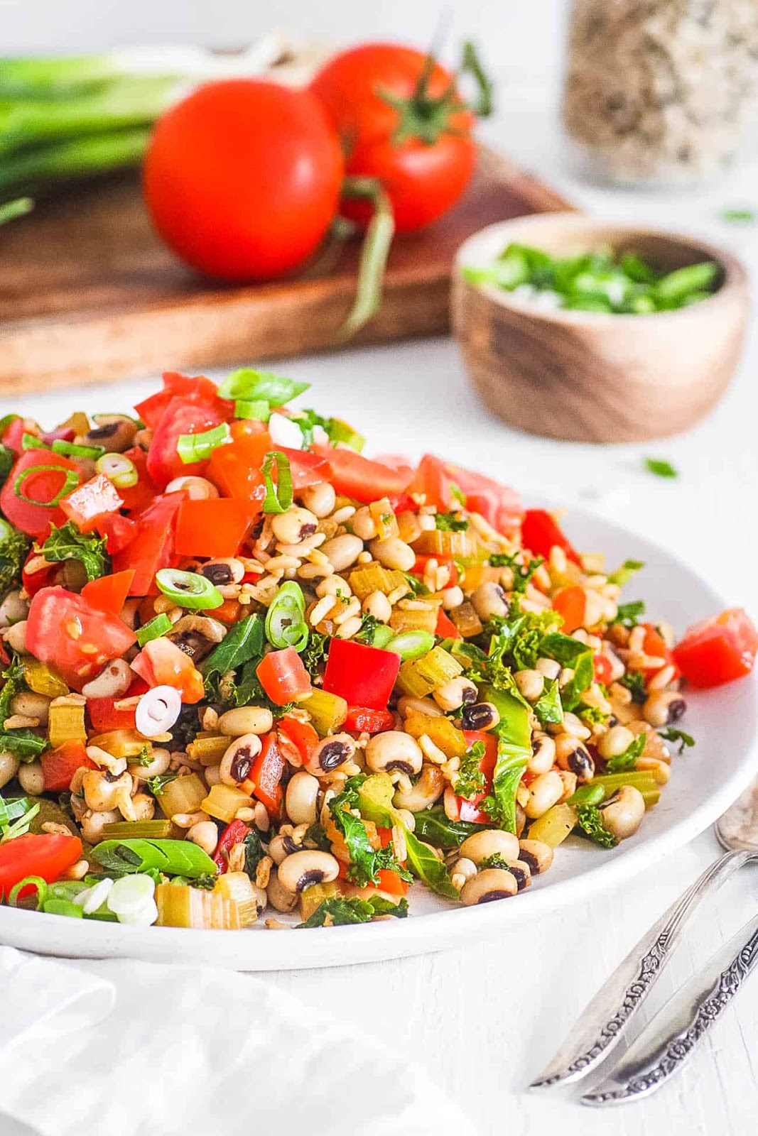 Blacked eyed peas served with mixed veggies on a white plate.