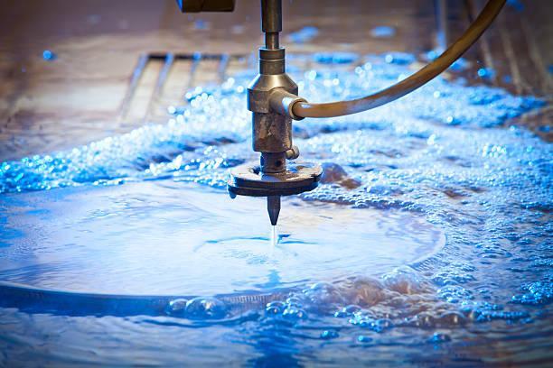 Waterjet Cutting Machine Detail Waterjet cutting nozzle  close-up from metalwork industry. CNC waterjet machine at work cutting a steel plate. abrasive waterjet stock pictures, royalty-free photos & images