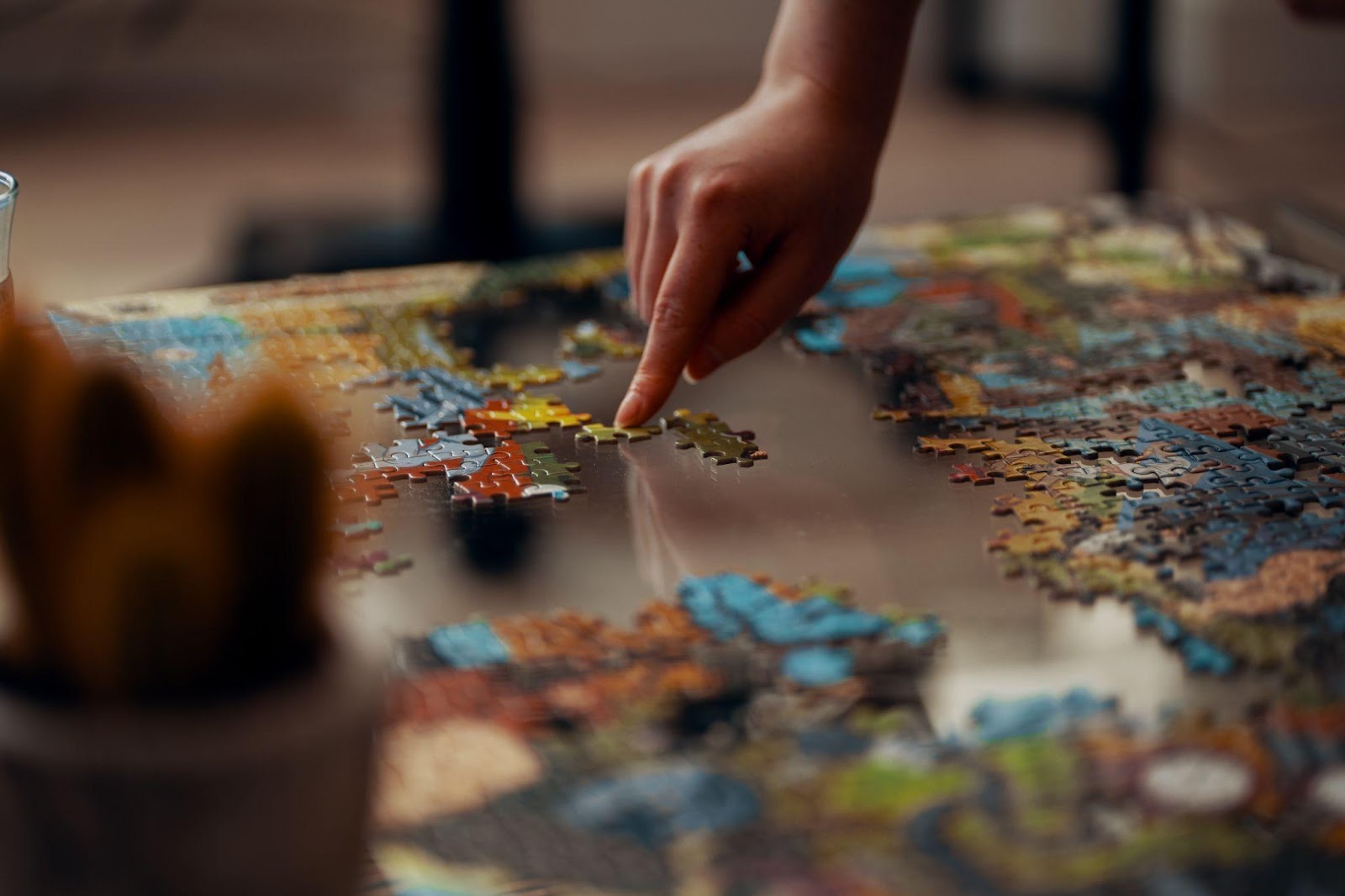 Colorful Jigsaw Puzzle with Person Moving a Piece with One Finger