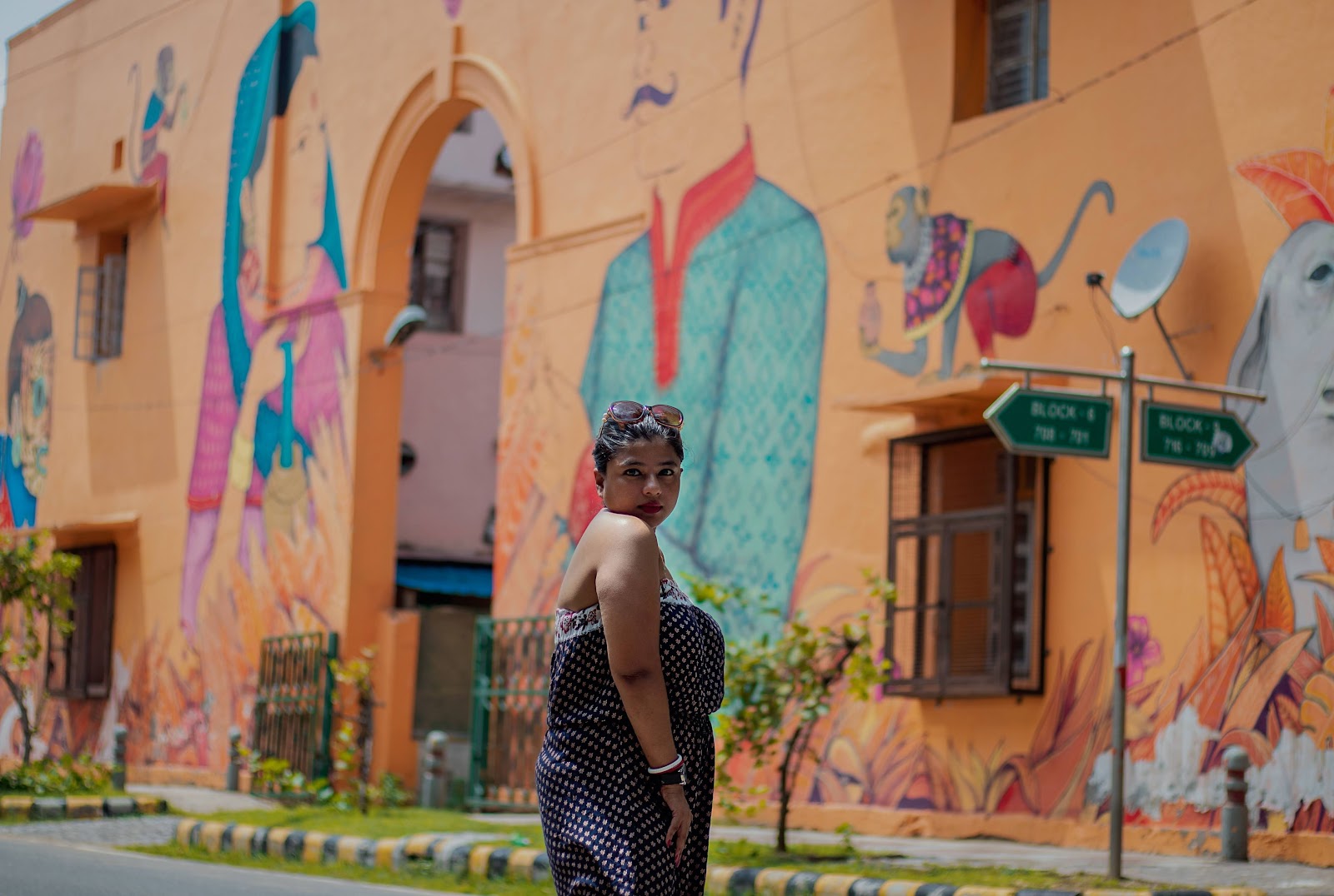A woman posing in front of colorful houses