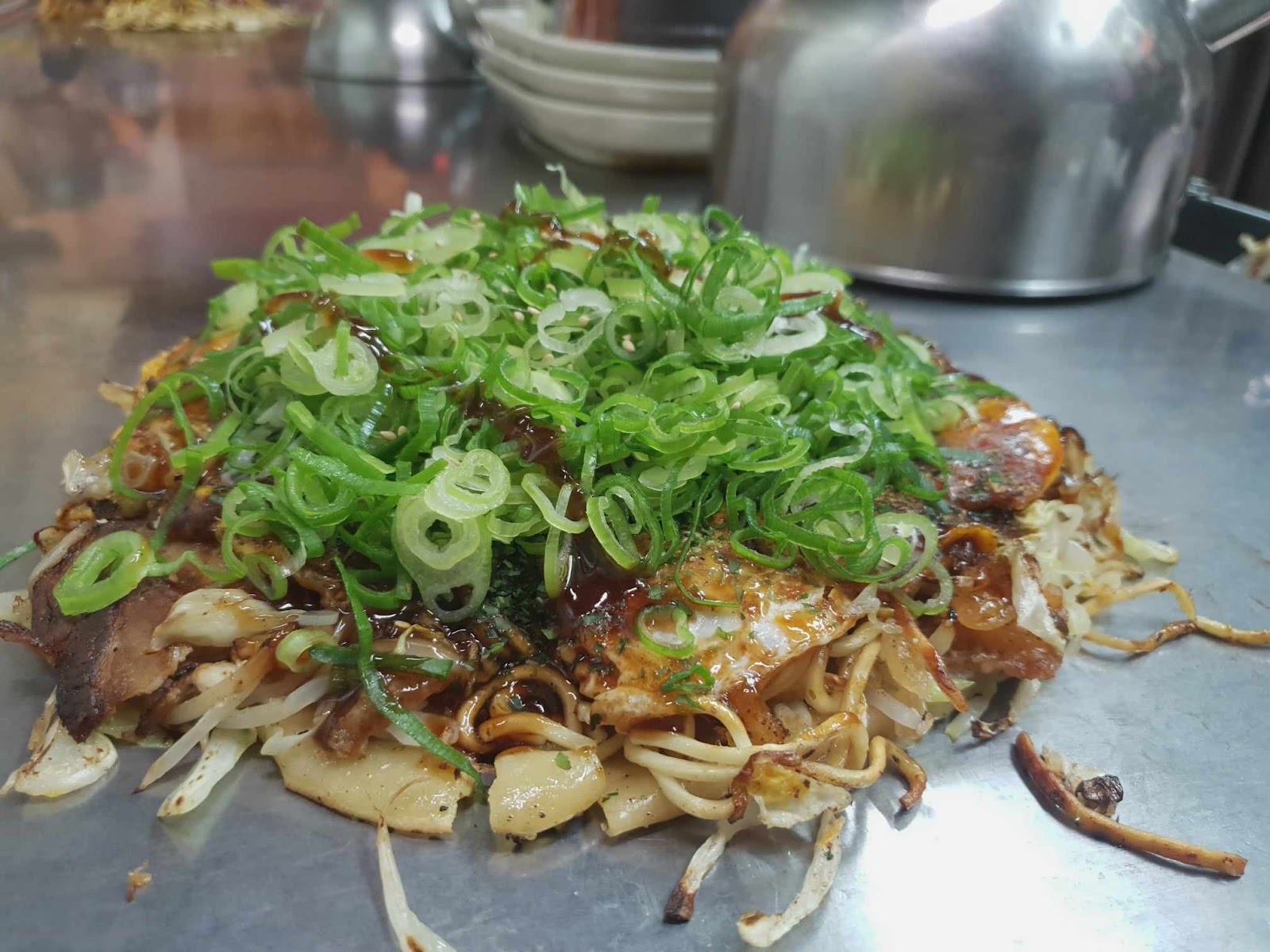 Daimarudo okonomiyaki deluxe with green onions on top
