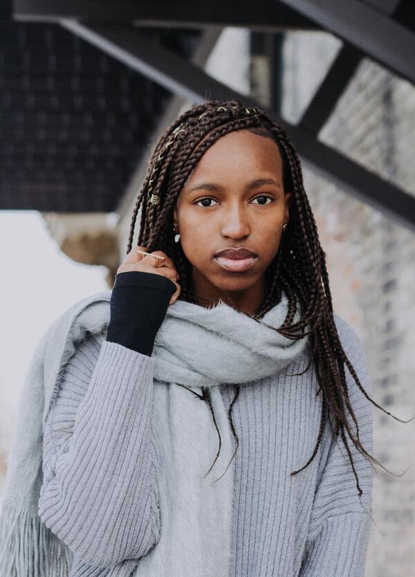 Mulher negra com o cabelo trançado posando para a foto