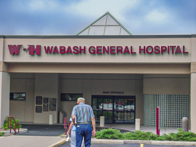 Two people walk toward the entrance of the Wabash General Hospital. 