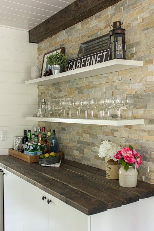 farmhouse drink bar with white floating shelves, rustic signs, shiplap, distressed wood countertop and large mosaic stone tile backsplash