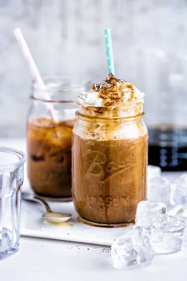 Vietnamese iced cold brew coffee with whipped cream and caramel served in a mason jar