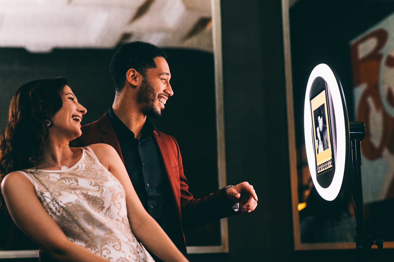 Two happy wedding guests smiling in a photo booth