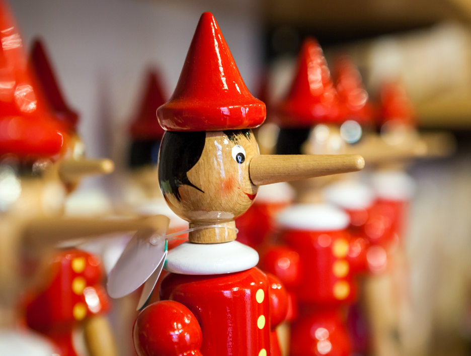 Image shows a market stall with wooden Pinocchio toys 