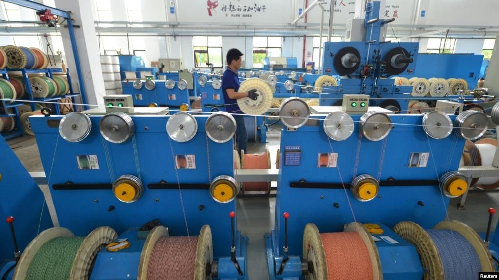 中国浙江省湖州市的一个通讯设备厂光纤生产线上的工人在工作。(2020年5月15日)