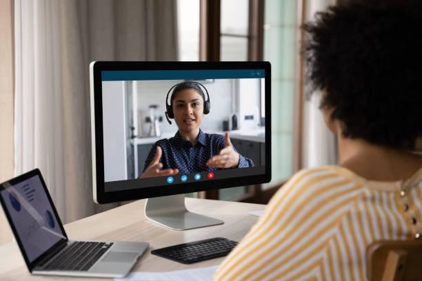 African American customer woman talking to support service employee African American customer woman talking to support service employee, operator on video call. Female business coworkers discussing project marketing report on distance virtual chat at computer monitor skype stock pictures, royalty-free photos & images