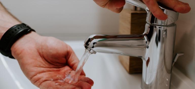 A person using a traditional faucet