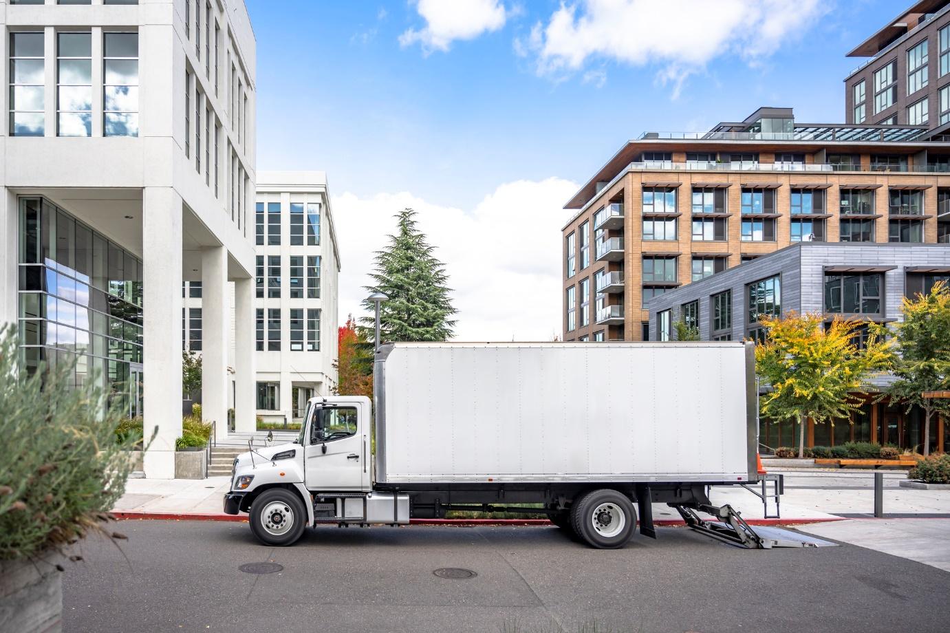 a white interstate moving company truck parked in front of an apartment building