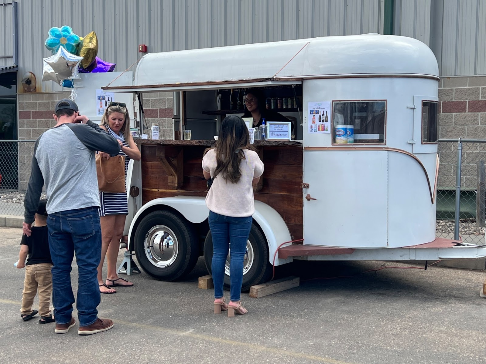 Adults and children line up at the On the Rocks mobile bar for drinks and treats at The Family Center/La Familia’s annual BELONG spring fundraiser.