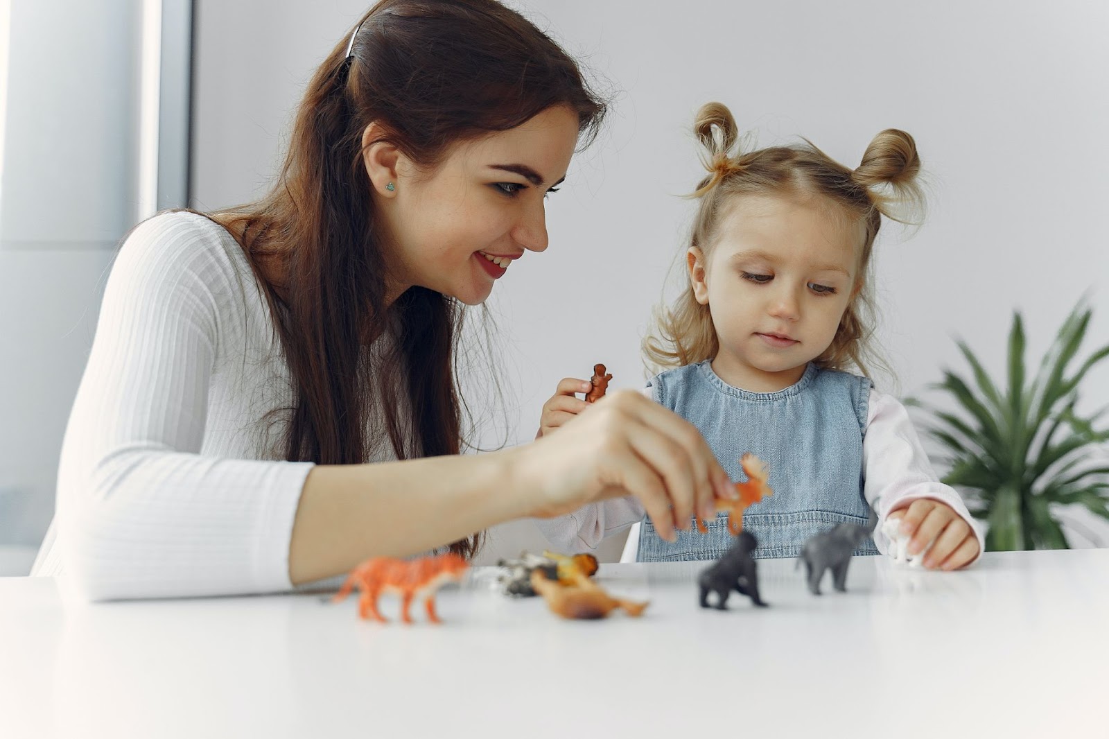 Teacher showing a child how to play with her toys