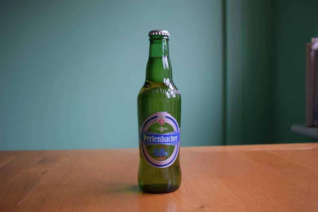 Unopened bottle of Perlenbacher 0.0% Non-Alcoholic Lager sitting on a table