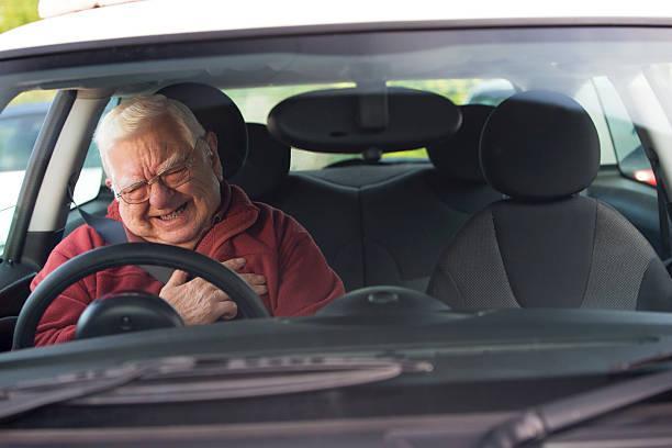 Senior Driver in Distress Old man holding his chest in pain while driving a car heart atatck while driving stock pictures, royalty-free photos & images