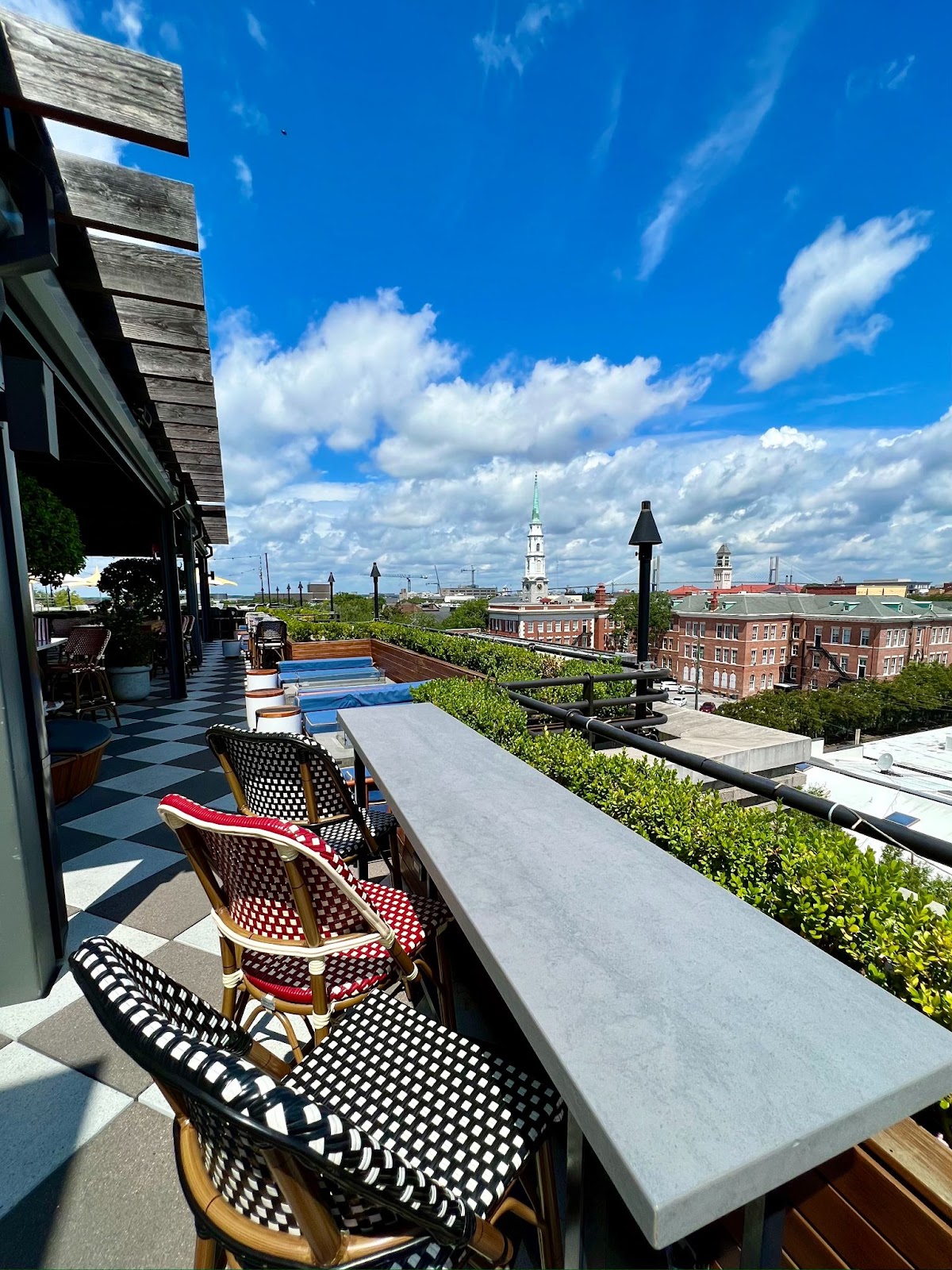 a rooftop patio with chairs and a pool