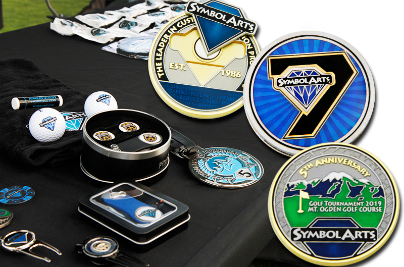 variety of custom recognition items on a table like badges, pins, and coins